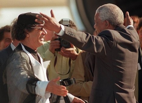 Tổng thống Nam Phi Nelson Mandela đón chào ông Gaddafi tại sân bay Cape Town. Ông Gaddafi đến Nam Phi để dự lễ nhận chức tổng thống Nam Phi của ông Thabo Mbeki vào tháng 6/1999.